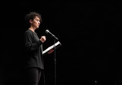 Poet reading on stage.